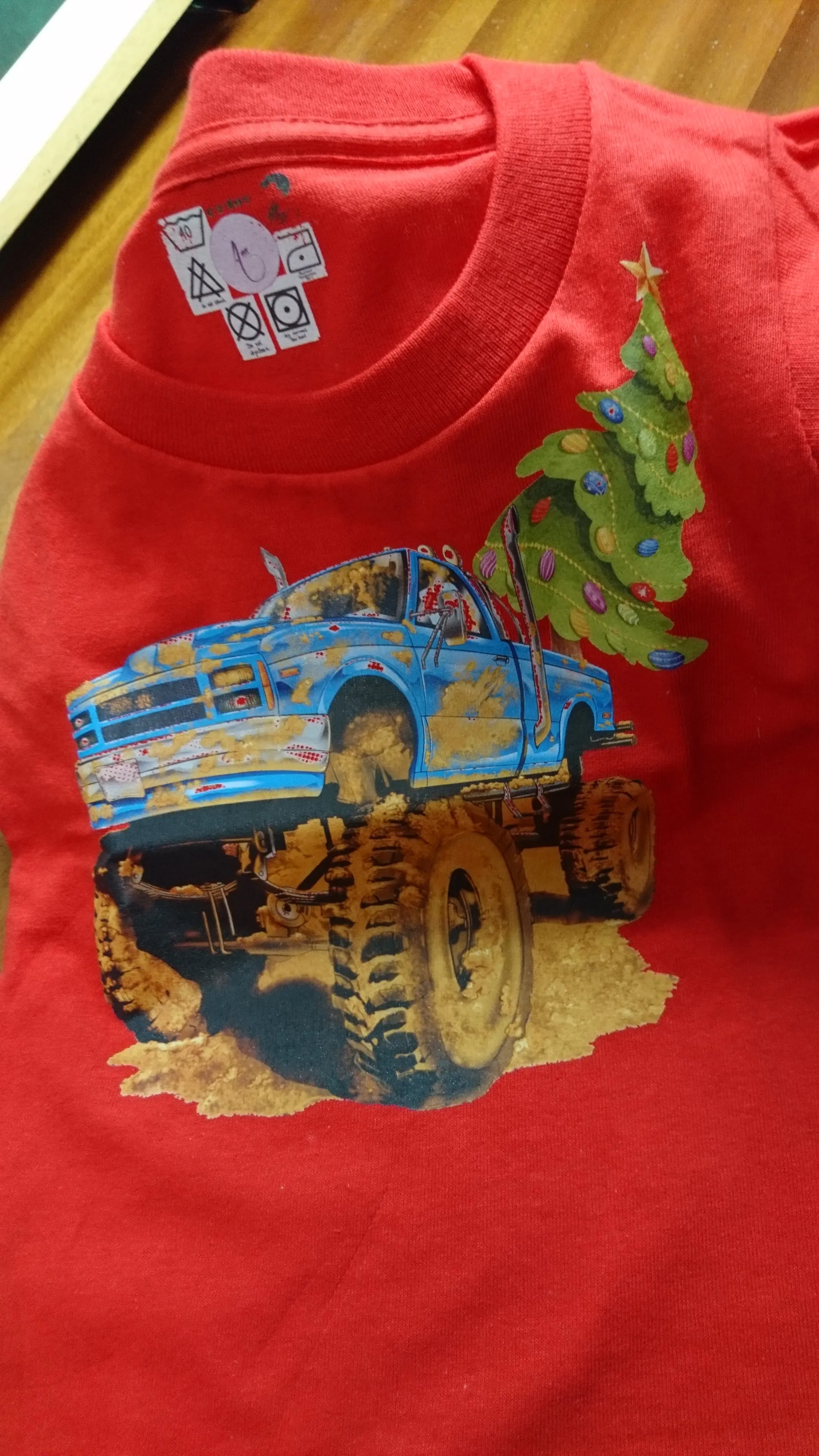 T-Shirts with the print of The Muddy Monster Truck carrying a Christmas Tree. Comfortable, soft Tees for Toddlers, Youth and Adults.